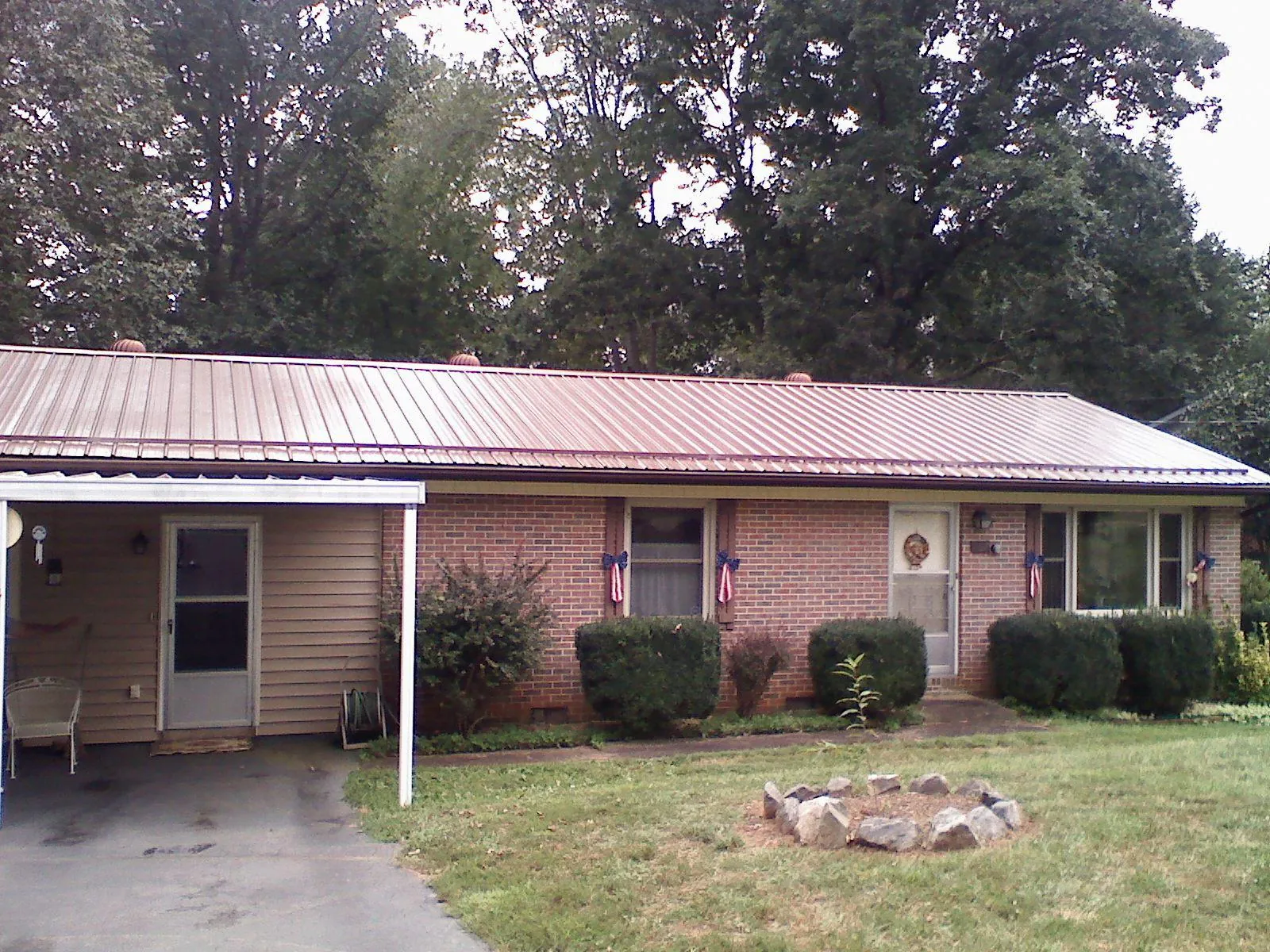 Bronze metal roof and carport on a brick ranch home in Maynard